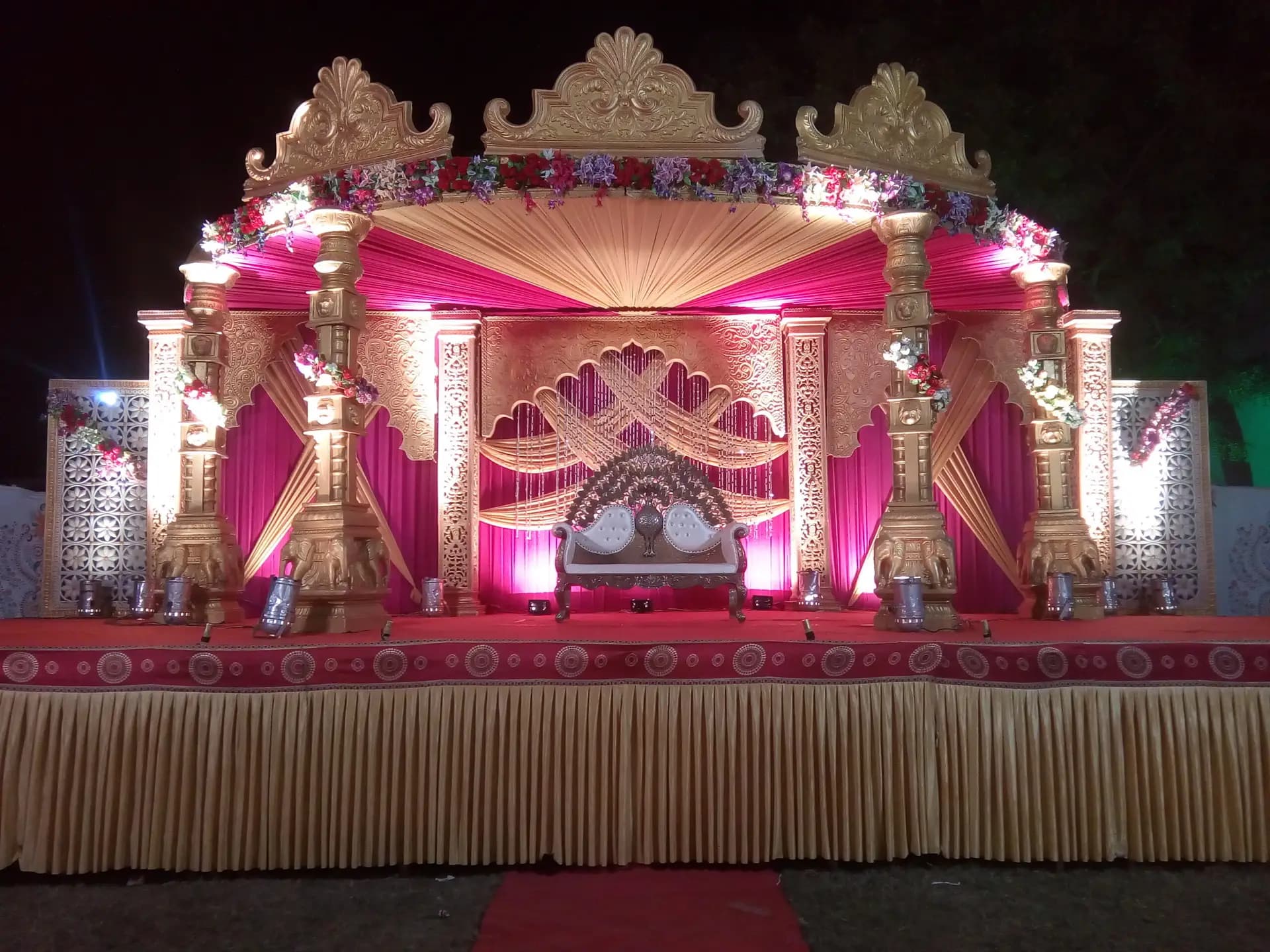 Pink and gold wedding stage with floral backdrop